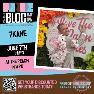 7Kane smiling in a floral suit jacket in front of a colorful flower wall at Pride on the Block 2025