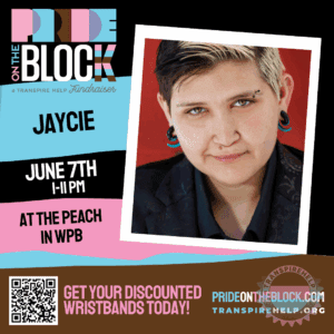 Jaycie with short two-tone hair and stretched ears, smiling warmly against a red backdrop