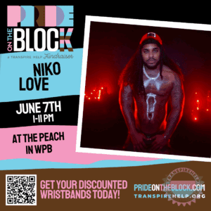 Niko Love shirtless in red lighting with shimmering body paint, radiating power and confidence at Pride on the Block 2025