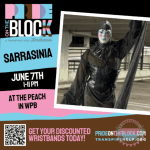 Sarrasinia in a sheer black outfit with bold face paint, standing in a parking garage setting at Pride on the Block 2025